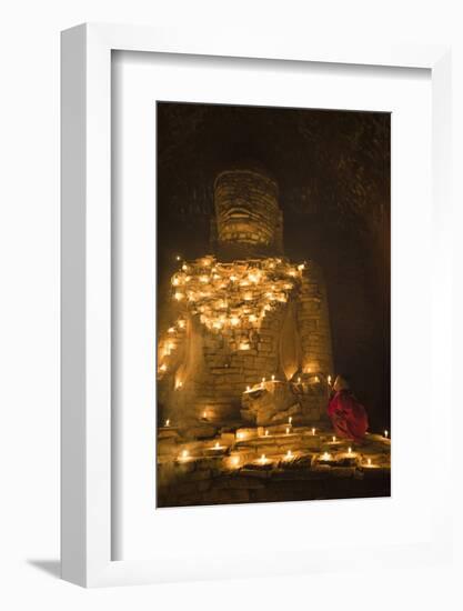 Bagan, Mandalay region, Myanmar (Burma). Young monk praying at a giant brick-make statue of the Bud-Marco Bottigelli-Framed Photographic Print