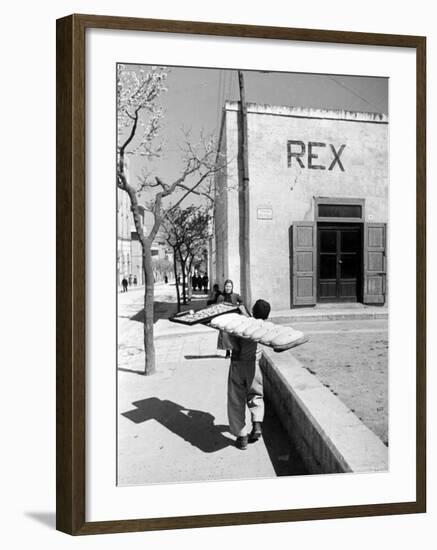 Baker's Apprentice Carrying a Large Tray of Bread Dough-Alfred Eisenstaedt-Framed Photographic Print