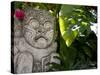 Bali, Ubud, a Stone Carving, Adorned with a Hibiscus Flower, Sits in Tropical Gardens-Niels Van Gijn-Stretched Canvas