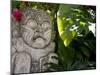 Bali, Ubud, a Stone Carving, Adorned with a Hibiscus Flower, Sits in Tropical Gardens-Niels Van Gijn-Mounted Photographic Print