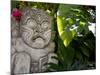 Bali, Ubud, a Stone Carving, Adorned with a Hibiscus Flower, Sits in Tropical Gardens-Niels Van Gijn-Mounted Photographic Print