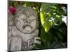Bali, Ubud, a Stone Carving, Adorned with a Hibiscus Flower, Sits in Tropical Gardens-Niels Van Gijn-Mounted Photographic Print