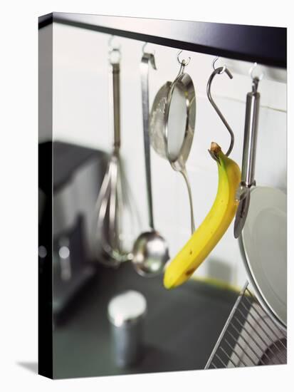 Banana and Kitchen Tools Hanging on Hooks in Kitchen-Kröger & Gross-Stretched Canvas