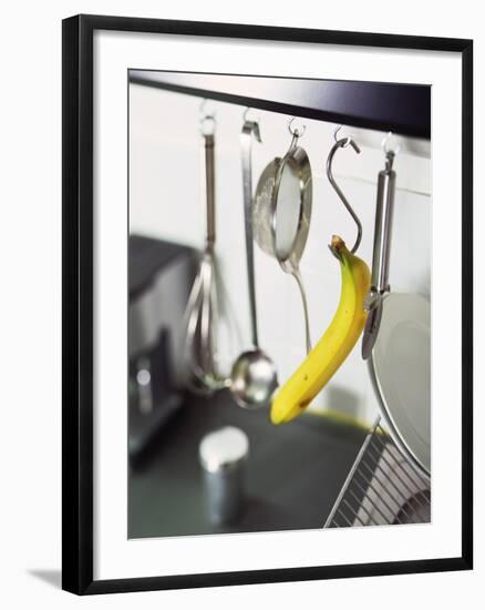 Banana and Kitchen Tools Hanging on Hooks in Kitchen-Kröger & Gross-Framed Photographic Print