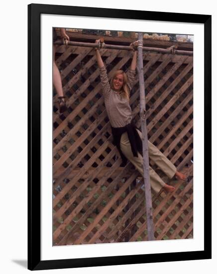 Barefoot Girl Swinging on Structure Containing Baby Chicks in Coop, Woodstock Music and Art Fair-John Dominis-Framed Photographic Print