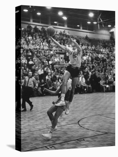 Basketball Player Tom Gola Leaping in the Air to Make a Shot During a Basketball Game-null-Stretched Canvas