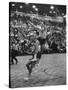 Basketball Player Tom Gola Leaping in the Air to Make a Shot During a Basketball Game-null-Stretched Canvas