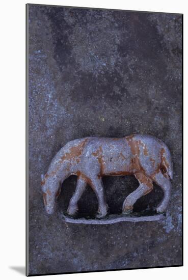 Battered Lead Model of Grazing Horse Lying on Tarnished Metal-Den Reader-Mounted Photographic Print