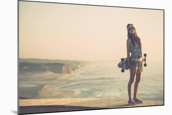 Beautiful And Fashion Young Woman Posing With A Skateboard-iko-Mounted Art Print