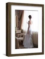 Beautiful Bride in White Wedding Dress Standing in Her Bedroom and Looking in Window-Malyugin-Framed Photographic Print