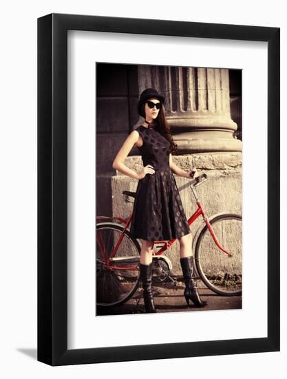 Beautiful Brunette Standing near Her Old Bicycle over City Background. Retro Style.-prometeus-Framed Photographic Print