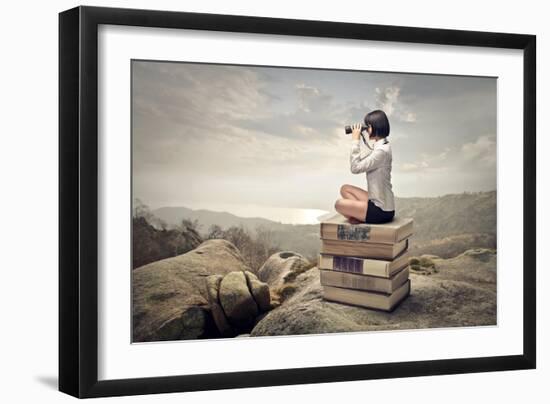 Beautiful Woman Sitting On A Pile Of Old Books Watching With Binoculars-olly2-Framed Art Print