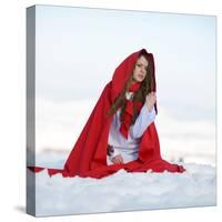 Beautiful Woman with Red Cloak Sitting on the Snow in Winter-mirceab-Stretched Canvas