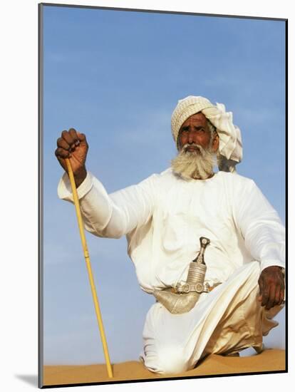 Bedouin Man Kneels on Top of a Sand Dune in the Desert-John Warburton-lee-Mounted Photographic Print