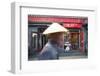 Beijing, China. Old Man with Conical Hat Passing in Front of a Shop in a Hutong of Beijing-Matteo Colombo-Framed Photographic Print