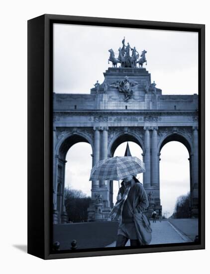 Belgium, Brussels; a Girl Walking with an Umbrella in Front of the Arc Du Triomphe-Ken Sciclina-Framed Stretched Canvas