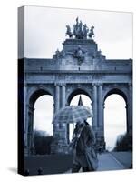 Belgium, Brussels; a Girl Walking with an Umbrella in Front of the Arc Du Triomphe-Ken Sciclina-Stretched Canvas