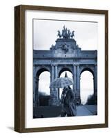 Belgium, Brussels; a Girl Walking with an Umbrella in Front of the Arc Du Triomphe-Ken Sciclina-Framed Photographic Print