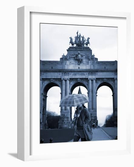 Belgium, Brussels; a Girl Walking with an Umbrella in Front of the Arc Du Triomphe-Ken Sciclina-Framed Photographic Print