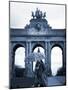 Belgium, Brussels; a Girl Walking with an Umbrella in Front of the Arc Du Triomphe-Ken Sciclina-Mounted Photographic Print