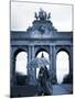 Belgium, Brussels; a Girl Walking with an Umbrella in Front of the Arc Du Triomphe-Ken Sciclina-Mounted Photographic Print