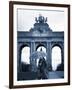 Belgium, Brussels; a Girl Walking with an Umbrella in Front of the Arc Du Triomphe-Ken Sciclina-Framed Photographic Print
