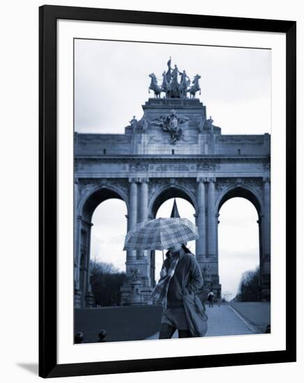 Belgium, Brussels; a Girl Walking with an Umbrella in Front of the Arc Du Triomphe-Ken Sciclina-Framed Photographic Print