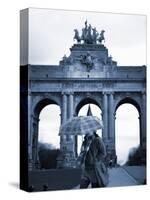 Belgium, Brussels; a Girl Walking with an Umbrella in Front of the Arc Du Triomphe-Ken Sciclina-Stretched Canvas