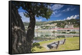 Bernina Express train runs past the village of St. Moritz surrounded by lake, Canton of Graubunden,-Roberto Moiola-Framed Stretched Canvas