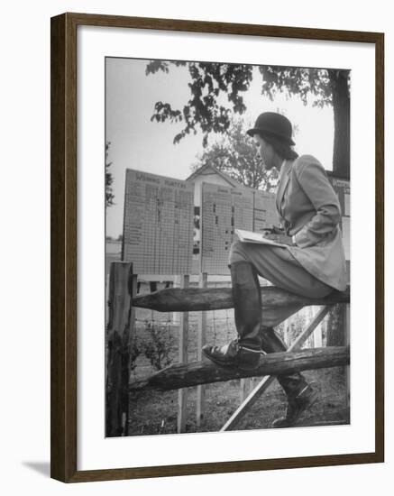 Betty Jane Baldwin Sitting on Fence and Looking at Official Board at Warrenton Horse Show-Martha Holmes-Framed Photographic Print