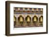 Bhutan. Spinning prayer wheels along a temple wall.-Brenda Tharp-Framed Photographic Print