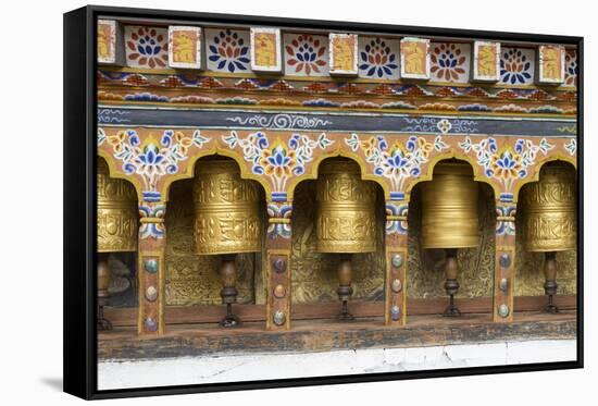 Bhutan. Spinning prayer wheels along a temple wall.-Brenda Tharp-Framed Stretched Canvas