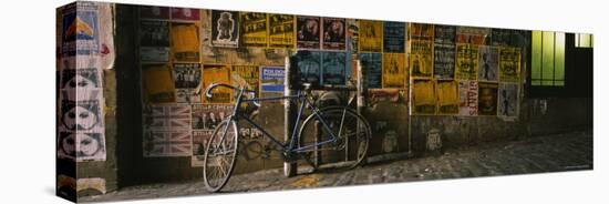 Bicycle Leaning Against a Wall with Posters in an Alley, Post Alley, Seattle, Washington, USA-null-Stretched Canvas