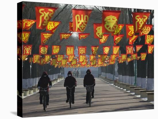 Bicycle Riders at Entranceway to Festival, Ice and Snow Festival, Harbin, Heilongjiang, China-Walter Bibikow-Stretched Canvas