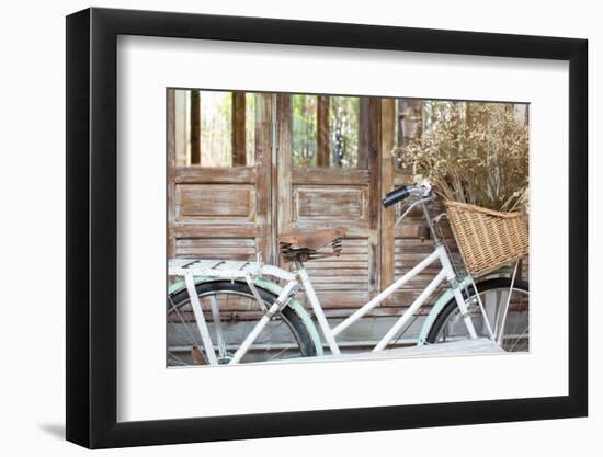 Bicycle with a Basket of a Dried Bouquet Flower Stand in Front of Wooden and Rustic House Backgroun-WichitS-Framed Photographic Print