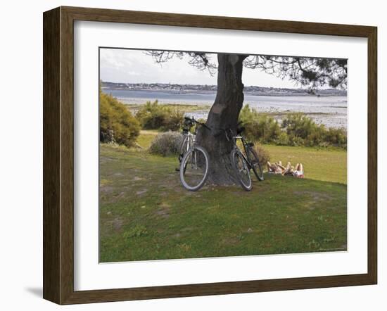 Bicycles by Tree and Couple Relaxing on the Grass, St. Pol De Leon, Carentac in Distance, Brittany-David Hughes-Framed Photographic Print
