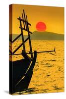 Big red setting sun beyond fishing boat moored off beach south of the city, Otres Beach, Cambodia-Robert Francis-Stretched Canvas