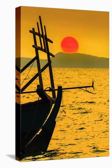 Big red setting sun beyond fishing boat moored off beach south of the city, Otres Beach, Cambodia-Robert Francis-Stretched Canvas