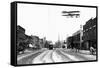 Biplane over a Small Town-J.H. Cave-Framed Stretched Canvas