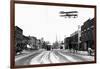 Biplane over a Small Town-J.H. Cave-Framed Photographic Print