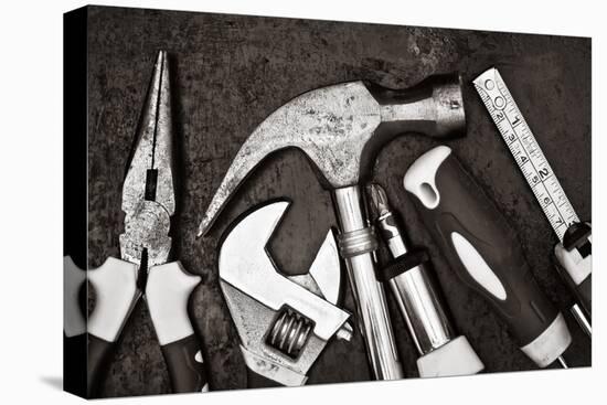 Black and White Image of a Set of Tools on a Textured Metallic Background-Kamira-Stretched Canvas