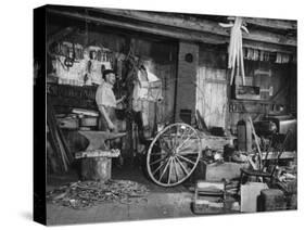 Blacksmith Working in His Shop-John Phillips-Stretched Canvas