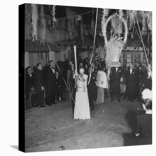 Blind Folded Woman Trying to Split Open the Pinata, During Traditional Pre-Christmas Celebration-Ed Clark-Stretched Canvas