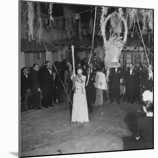 Blind Folded Woman Trying to Split Open the Pinata, During Traditional Pre-Christmas Celebration-Ed Clark-Mounted Photographic Print