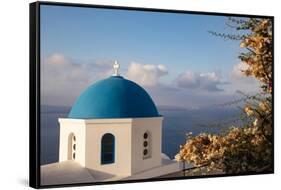 Blue domed Greek Orthodox church with bougainvillea flowers in Oia, Santorini, Greece.-Michele Niles-Framed Stretched Canvas