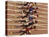 Blurred Action of Male Runners Starting a 100 Meter Sprint Race-Paul Sutton-Stretched Canvas