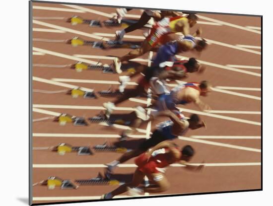 Blurred Action of Male Runners Starting a 100 Meter Sprint Race-Paul Sutton-Mounted Photographic Print