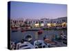 Boats in Harbour at Dusk, with Shops and Restaurants of Mykonos Town in the Background, Greece-Fraser Hall-Stretched Canvas