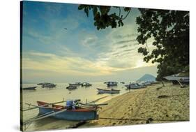 Boats off the town beach at sunset with Manadotua Island beyond, Bunaken, North Sulawesi-Robert Francis-Stretched Canvas