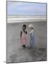 Boy and Girl on Beach Listening to Sea Shell-Nora Hernandez-Mounted Giclee Print